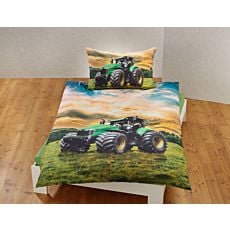 Linge de lit avec un grand tracteur sur un pré vert